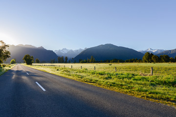 Country road among the meadows and mountains in New Zealand southland