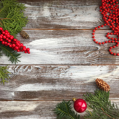 Christmas composition with copy space. Сhristmas ball and beads, pine cones, fir branches on wooden background. Flat lay, top view