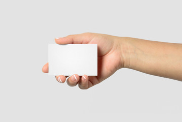 Mockup of female hand holding a Business Card isolated on light grey background. Size 85x 55 mm.