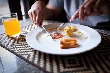  a young woman's hands as she is having breakfast