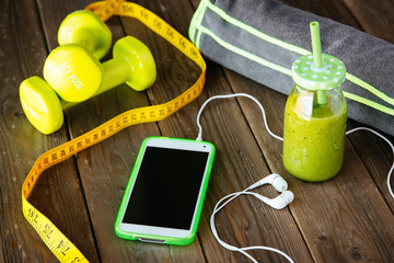Smartphone and detox smoothie for fitness workout app or diet concept