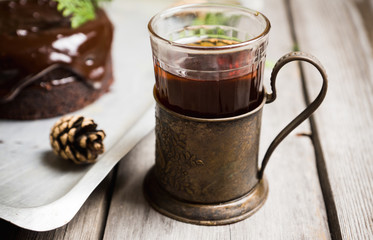 Black tea in glass with retro cup holder on the rustic background. Shallow depth of field.