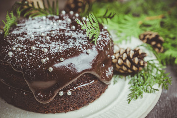 Creamy cake with chocolate glaze on the rustic background. Selective focus. Shallow depth of field. Toned image.