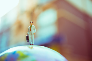 Miniature people, businessman standing on small world using as business concept - Vintage filter