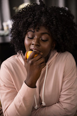 Schwarze Frau beißt in Orange