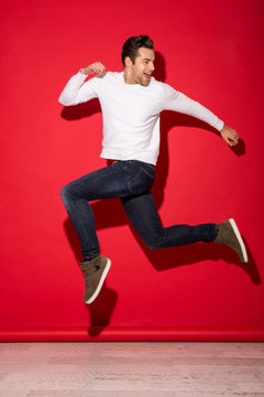 Full length image of happy man jumping and looking back