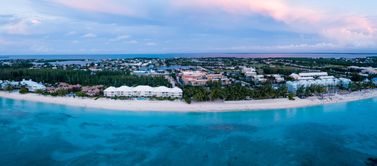 panoramisch luchtfoto van zeven mijl strand in het tropische paradijs van de Kaaimaneilanden in de Caribische Zee na zonsondergang