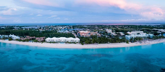 Zelfklevend Fotobehang Seven Mile Beach, Grand Cayman panoramisch luchtfoto van zeven mijl strand in het tropische paradijs van de Kaaimaneilanden in de Caribische Zee na zonsondergang