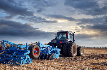 Tractor working in the field at sunset