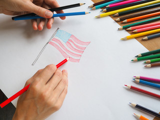 Girl drawing USA flag on white background

