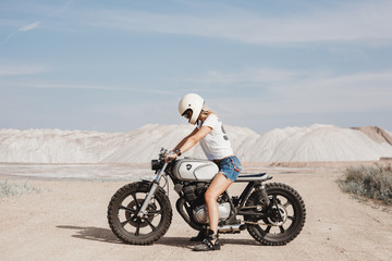 girl traveling by motorbike across the desert