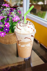 Ice mocha frappe served with whipping cream in plastic cup.