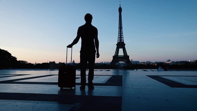 tourist in Paris looking at Eiffel tower silhouette, tourism sightseeing in Europe