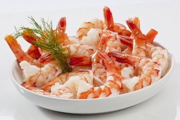 Steamed Jumbo headless shrimps with deli leaves and Lemon on white plate on white background 
