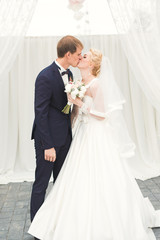 Perfect couple bride, groom posing and kissing in their wedding day