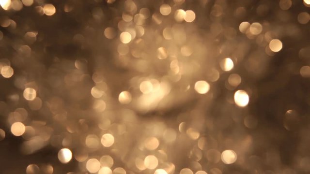 Rotating bokeh from golden tinsel. Christmas and new year background.