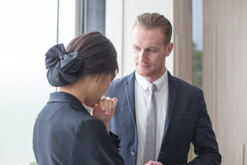 A businessman is helping or take care woman. She asks him for help at office.
