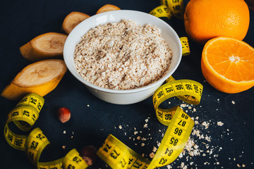 oat flakes for breakfast for slimming with fruit on a dark background