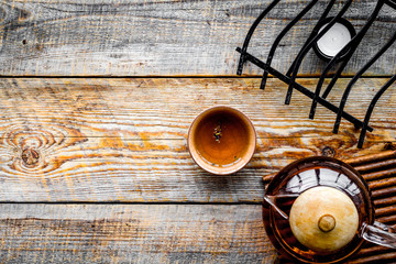 Tea break. Cookware fo tea ceremony. Tea pot and cup on rustic wooden background top view copyspace