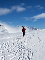 Fototapeta na wymiar Skier with skis go up to top of snowy mountain