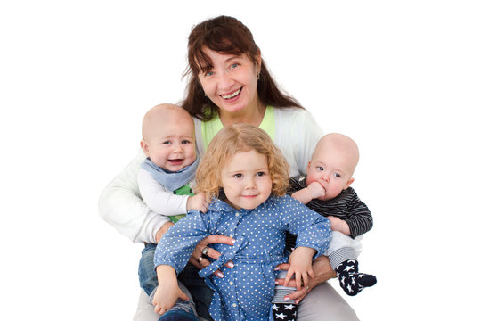 Cheerful mature woman posing with grandchildren smiling at camera. 