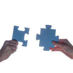 Silhouette of two hand holding couple of blue jigsaw puzzle piece on white background. concept - connection idea, sign, symbol, friendship, decision, success