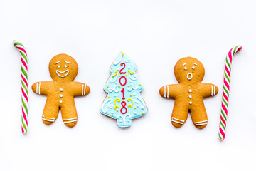 Cookies for New Year. Gingerbread man and spruce with lettering 2018 on white background top view