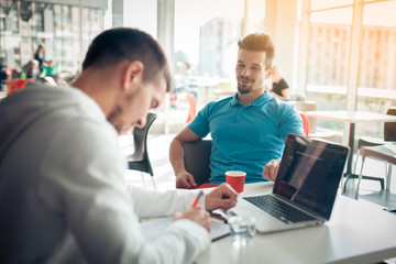 two handsome guys planning in cafe;