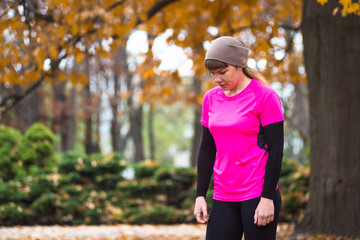 Young sport woman doing exercises during autumn training outside