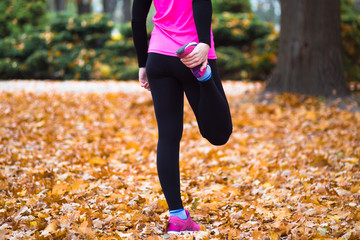 Young sport woman doing exercises during autumn training outside