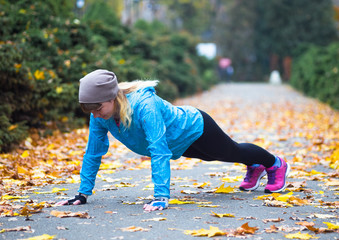 Young sport woman doing exercises during autumn training outside
