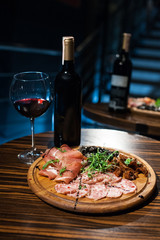 meat plate with bottle of red wine;