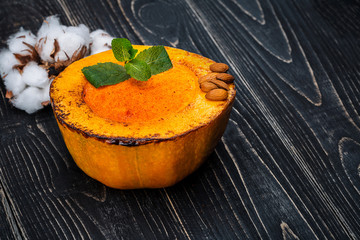 Healthy natural food, pumpkin cream soup on a black wooden background