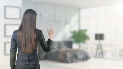 Young beautiful business woman and creative designer standing over blured interior background