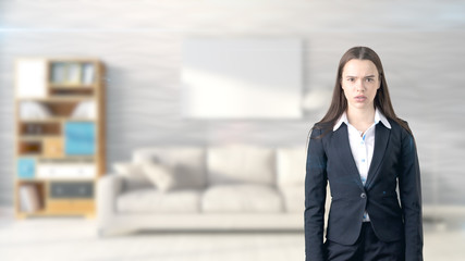 Young beautiful business woman and creative designer standing over blured interior background