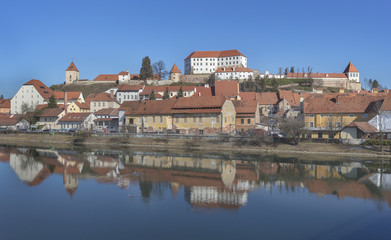 Old town Ptuj with mighty medieval castle on the hill and reflections in river Drava, Slovenia
