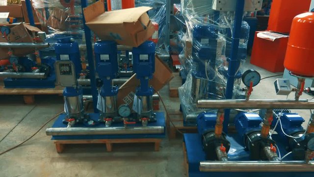 A number of new water pumps before a large-scale assembly in a factory interior