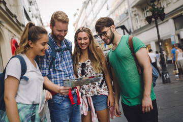 Young happy tourists sightseeing in city