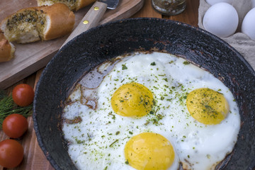 appetizing fried eggs in an old frying pan