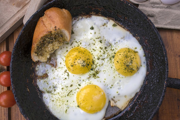 appetizing fried eggs in an old frying pan