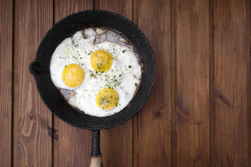 appetizing fried eggs in an old frying pan