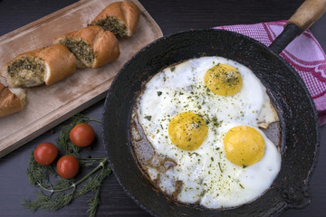appetizing fried eggs in an old frying pan