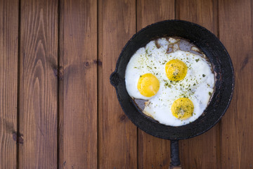 appetizing fried eggs in an old frying pan