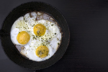 appetizing fried eggs in an old frying pan