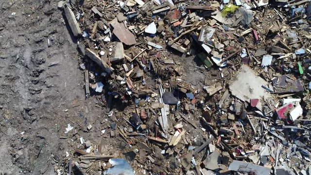 Aerial top down view moving over landfill site also known as tip dump rubbish dump garbage dump or dumping ground is site for disposal of waste materials by burial and oldest form of waste treatment