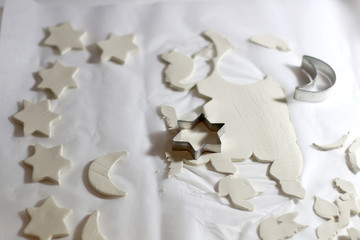 Making homemade Christmas decorations with white clay and cookie cutters. Selective focus.