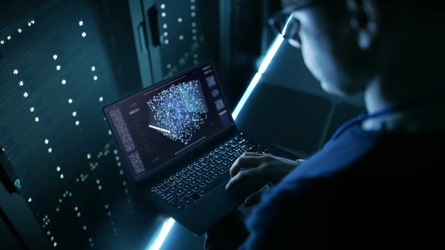 Data Center IT Engineer Holds Laptop and Works on the Neural Network AI Project.