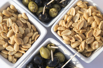 Arrangement of peanuts and olives in individual bowls