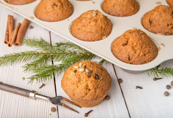 Christmas cupcakes with spices cloves, seeds and nuts in a baking dish on white wooden table