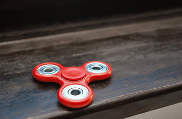 Fidget spinner on a wooden surface. Stress relieving toy